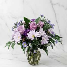 Pink roses and lavender daisies in a glass vase
