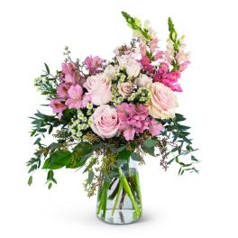 Pink roses and snapdragons in a clear glass vase