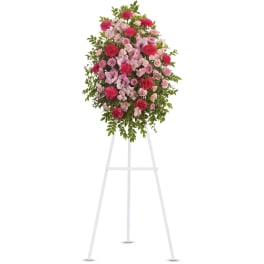 Pink and red floral standing spray on a white easel