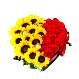 Heart-shaped box of yellow sunflowers and red roses with chocolates nestled among the blooms