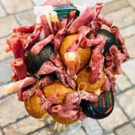 Bouquet made of cured meats and cheese in a clear vase