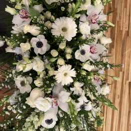 White floral spray with gerbera daisies, roses, and orchids