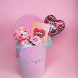 Pink gift box with a teddy bear, Valentine card, and heart balloon