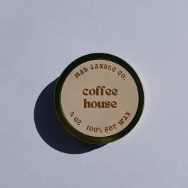 Round tin candle labeled coffee house