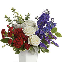Red and white roses with purple flowers in a white vase