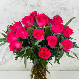 Hot pink roses arranged in a clear glass vase