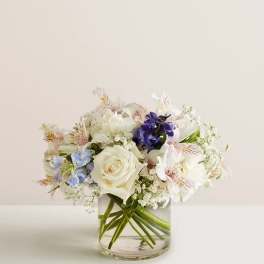 Bouquet of white and blue flowers in a clear glass vase