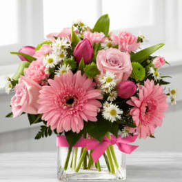 Pink mixed bouquet in a clear glass vase with a ribbon