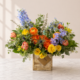 Colorful mixed flower arrangement in a rustic wooden box