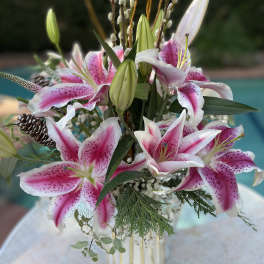 Pink and white lilies arranged in a striped vase