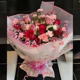 Pink and red rose bouquet wrapped in striped paper