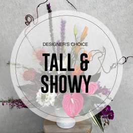 Tall floral arrangement in a white vase with pink and purple blooms