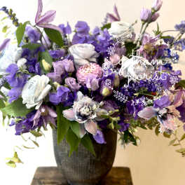 Purple and white mixed bouquet in a dark vase