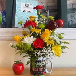 Colorful bouquet in a mug with red and yellow flowers and apple decorations