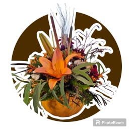 Orange lily arrangement in a pumpkin-shaped container