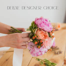 Handheld bouquet of pink peonies and peach roses with berries