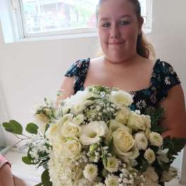Woman holding a large white bouquet of roses and hydrangeas