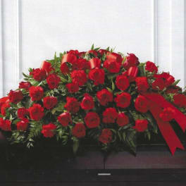 Large red rose casket spray with ribbon accents