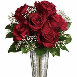 Red roses arranged in a silver vase with baby's breath