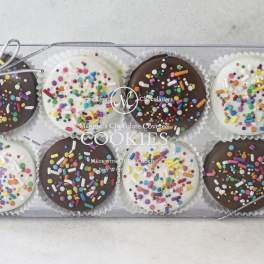 Box of chocolate-covered cookies with colorful sprinkles