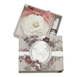 White fabric flower in a gift box with a pink ribbon and small bottle