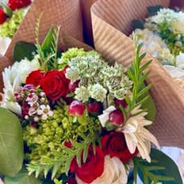 Bouquet of red roses and white flowers wrapped in brown paper