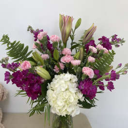 Pink and purple bouquet with white hydrangea in a glass vase