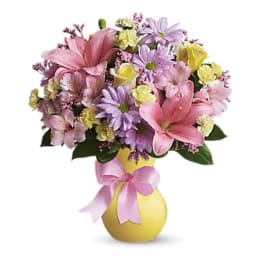Pink and lavender mixed bouquet in a yellow vase with a pink ribbon