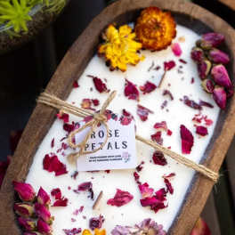 Oval candle topped with dried rose petals and small flowers