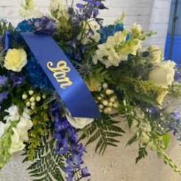 Large blue and white floral spray with a ribbon