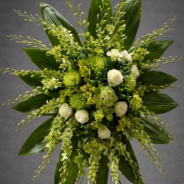 Green and white floral standing spray on a black easel