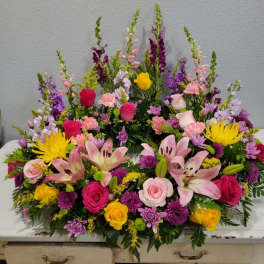 Large colorful floral arrangement with roses, lilies, and snapdragons
