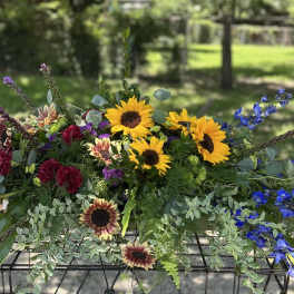 Mixed bouquet with sunflowers, blue delphinium, and burgundy blooms