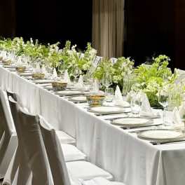 Long banquet table with white floral centerpieces and place settings