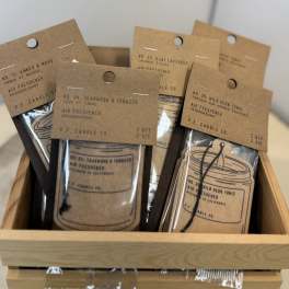 Assorted air freshener packets in a wooden tray