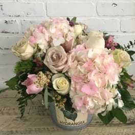 Pink and cream bouquet in a metal bucket with hydrangeas and roses