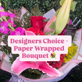 Paper-wrapped bouquet with pink and red flowers and a red rose