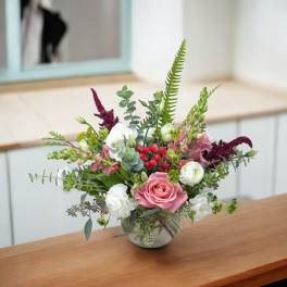 Mixed bouquet in a round glass vase with pink and white flowers