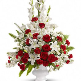 Red roses and white lilies in a white pedestal vase