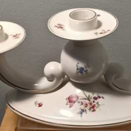 White ceramic three-arm candle holder with small floral decals