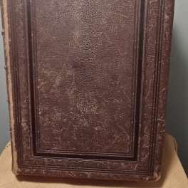 A worn brown rectangular decorative panel with raised border details