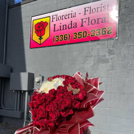 Large bouquet of red and white roses wrapped in burgundy paper