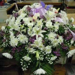 Large white floral spray with a lavender ribbon and bow