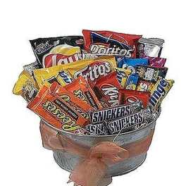 Metal bucket filled with assorted chips and candy bars, wrapped with a soft peach bow