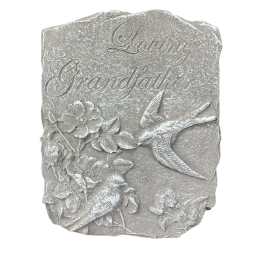 Gray memorial plaque with birds and flowers