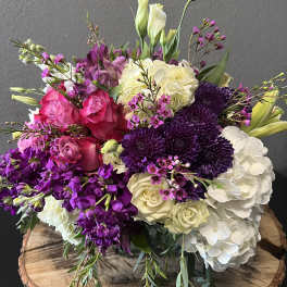 Bouquet of pink, purple, and white flowers on a wooden slab