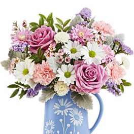 Pink and white mixed bouquet in a blue floral pitcher