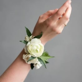 White floral wrist corsage on a person's wrist