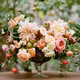 Pastel floral arrangement in a glass compote vase