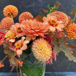 Two small tropical bouquets and one fall orange centerpiece